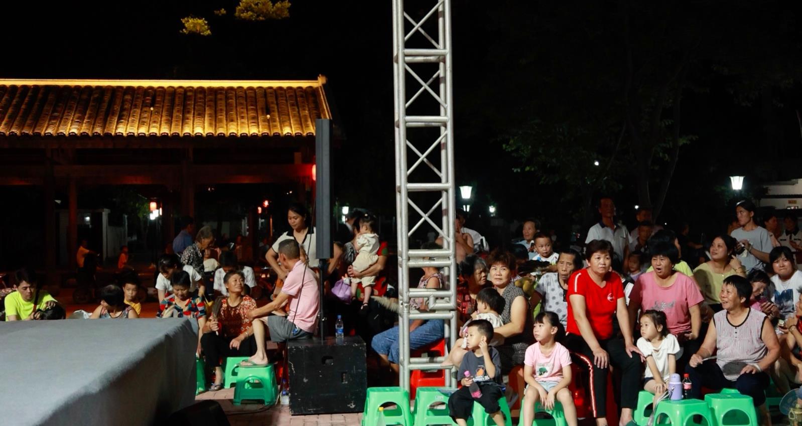 7月16日晚，村民们端坐成几排，享受着“文化大餐”。（王琳雅 摄）